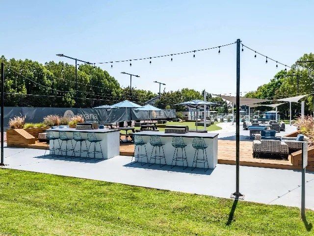 Outdoor kitchen, lawn and string lights at an apartment community
